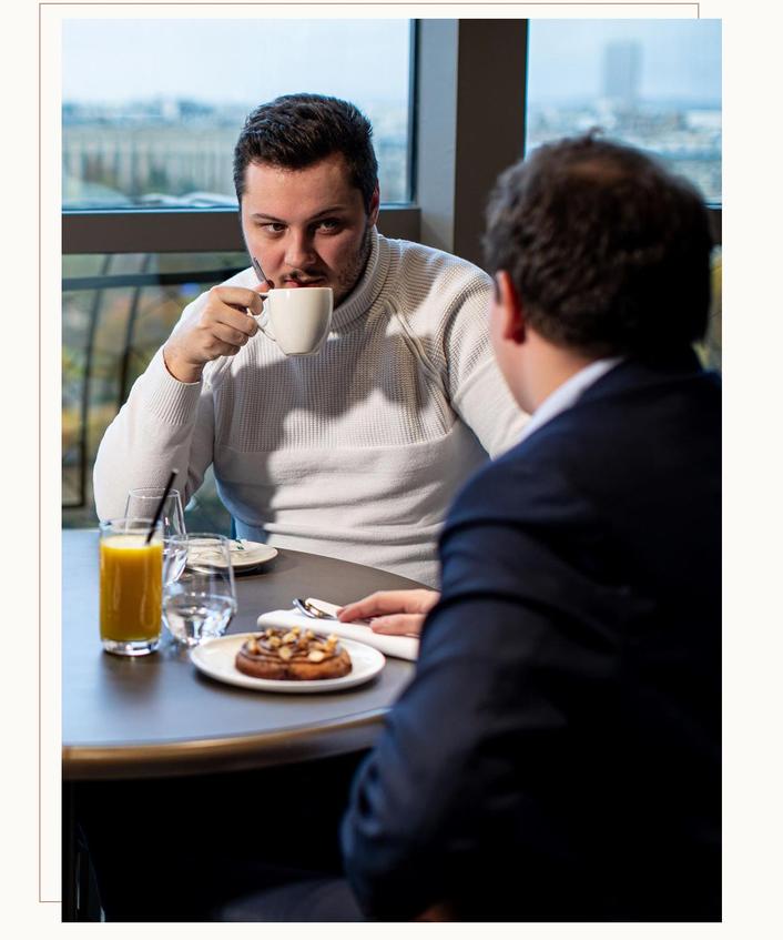 Two people enjoy a snack time and a coffee on the first floor of the Eiffel Tower